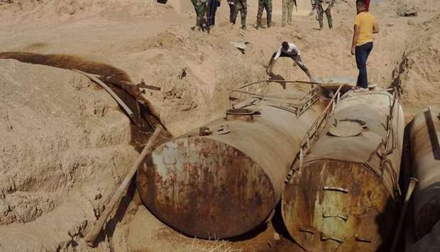 Iraqi forces unearth containers used by Islamic State group to store oil, near the former al bakara military base