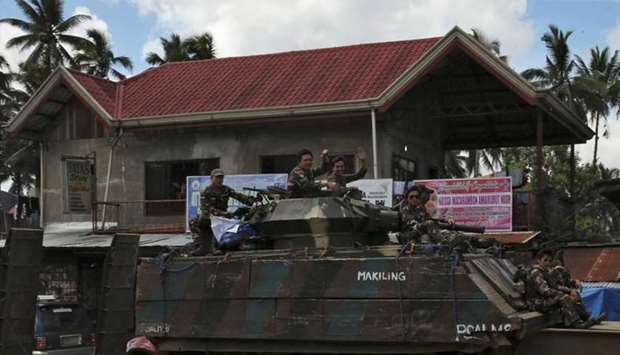 Government soldiers wave while atop of the tank after the send-off ceremony ending their combat duty against pro-Islamic State militant groups, after President Rodrigo Duterte announced the liberation of Marawi city on Monday, in Saguiaran, Lanao Del Sur, southern Philippines October 28, 2017.  Reuters