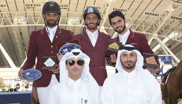 Winner of the Big Tour: 1.30/1.40m of the third leg of Hathab National Equestrian series Saeed Nasser al-Qadi (centre), second-placed Hamad Ali al-Attiyah (left) and third-placed Nasser al-Ghazali pose on the podium with Al Shaqabu2019s commercial manager Omar al-Mannai (foreground, left) and Event Director of Qatar Equestrian Federation Ali al-Rumaihi (foreground, right) yesterday. PICTURES: Lotfi Garsi