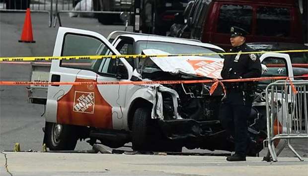 A police officer walks past the wreckage of a Home Depot pickup truck, a day after it was used in a terror attack, in New York on Wednesday.