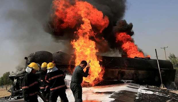 Afghan firefighters trying to extinguish the burning fuel tanker