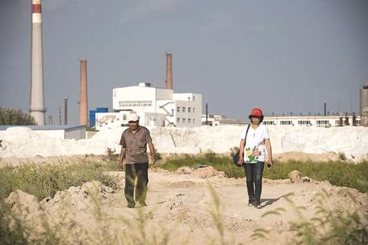 Farmer Wang Baoqin (right) walk on farmland polluted by the Qihua chemical plant in Yushutun.