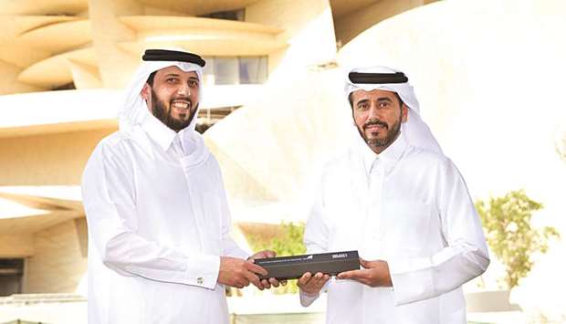 Mansoor bin Ebrahim al-Mahmoud and Ali al-Khalifa holding the award.