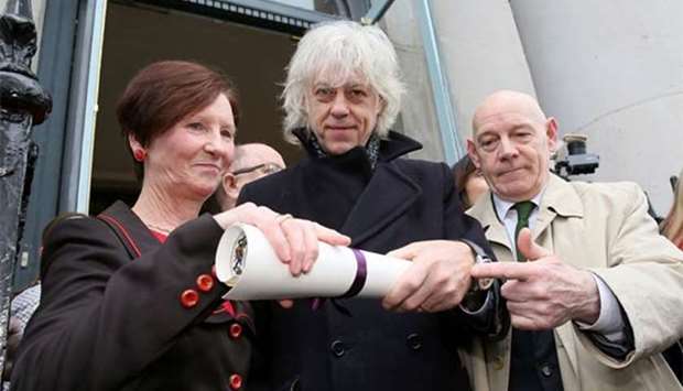 Irish musician Bob Geldof poses with Dublin City Hall's Oonagh Casey (left), and his Freedom of the City of Dublin scroll after handing it back at Dublin City Hall on Monday.