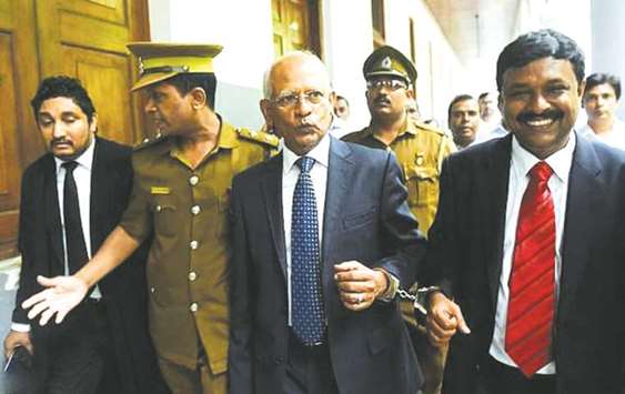 Another Rajapakse aide Lalith Weeratunga, third left, is escorted from the Colombo High Court in September after being convicted on corruption charges.