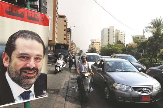 Cars pass next to a poster depicting Saad al-Hariri, who has resigned as Lebanonu2019s prime minister, in Beirut, yesterday.