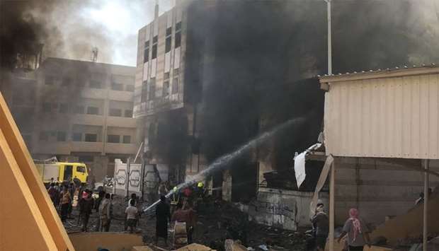 Yemeni firefighters douse flames following an explosion near a security post in the southern port city of Aden