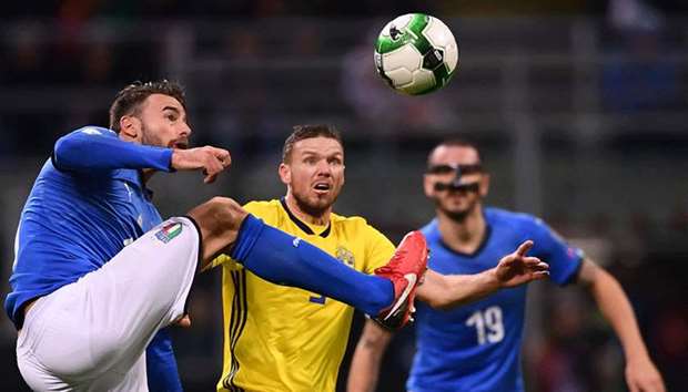 Swedenu2019s defender Martin Olsson (C) fights for the ball with Italyu2019s defender Andrea Barzagli during the FIFA World Cup 2018 qualification football match between Italy and Sweden, on November 13, 2017 at the San Siro stadium in Milan.