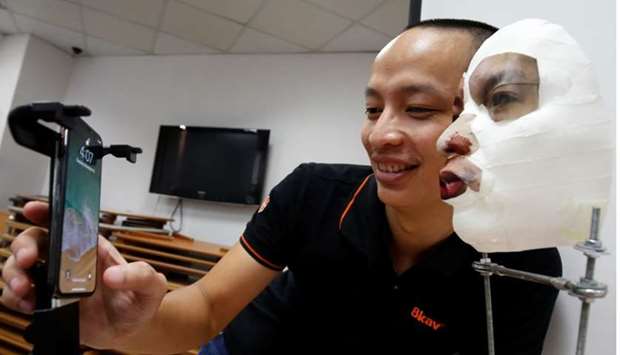 Ngo Tuan Anh, Vice President of Bkav, a Vietnamese cybersecurity firm, demonstrates iPhone X Apple's face recognition ID software with a 3D mask at his office in Hanoi, Vietnam.