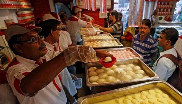 Customers buy u2018rosogollau2019 at a sweet shop in Kolkata on Tuesday.