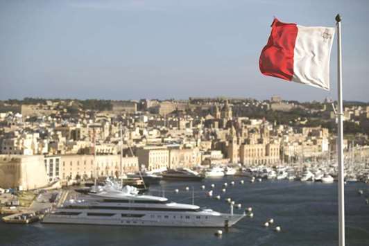 Luxury vessels sit moored at Vittoriosa Yacht Marina beyond the national flag of Malta flying in Valletta, Malta on February 2, 2017. Maltau2019s ambitions to introduce Islamic finance go back to 2008, when the islandu2019s financial services authority became the first regulator within the European Union to issue guidelines on Islamic finance.