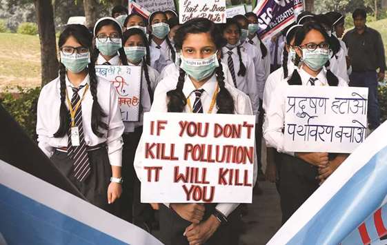 School children wearing pollution masks hold placards as they participate in a march to raise awareness of air pollution levels in New Delhi yesterday.