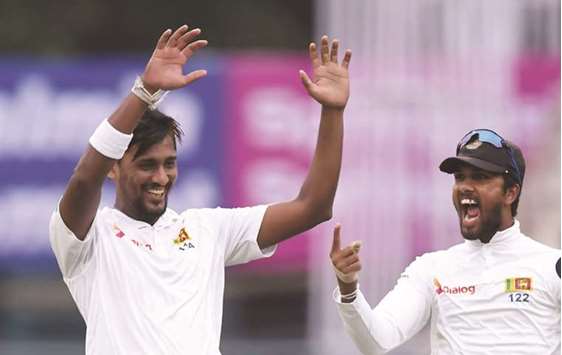 Sri Lankau2019s Suranga Lakmal and captian Dinesh Chandimal celebrate after taking the wicket of Indian captain Virat Kohli during the first day of the first Test at the Eden Gardens in Kolkata yesterday. (AFP)