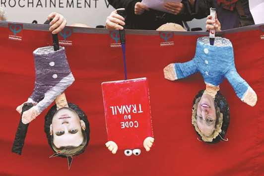 Supporters of the far-left opposition u2018France Insoumiseu2019 party perform a show with puppet caricatures of President Macron, a French labour law code, and Labour Minister Muriel Penicaud (right) during a demonstration in Paris against government labour reforms.
