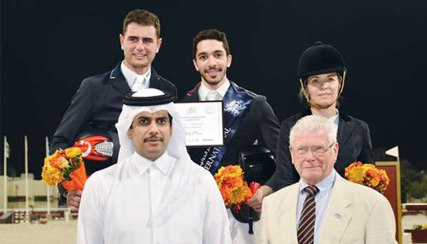 Winner Salman Mohamed al-Emadi (background centre), second-placed Derin Demirsoy (left) and third-placed Edwina Tops-Alexander celebrate with Qatar Equestrian Federation president Hamad bin Abdulrahman al-Attiyah (front left) on the podium of the feature event of QNB Qatar International Show Jumping Championship yesterday. PICTURES: Lotfi Garsi