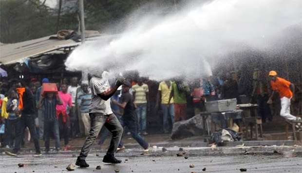 A supporter of Kenyan opposition leader Raila Odinga is sprayed with water by police in Nairobi on Friday.