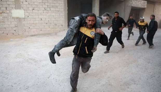 A wounded Syrian is carried by a member of the Syrian Civil Defence to a hospital in the rebel-held town of Arbin, in the Eastern Ghouta region on the outskirts of Damascus.