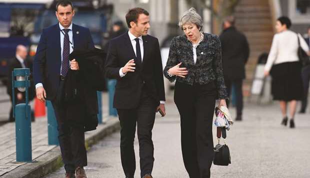 Franceu2019s President Emmanuel Macron and Prime Minister Theresa May talk while walking to the luncheon during the European Social Summit in Gothenburg, Sweden, yesterday.