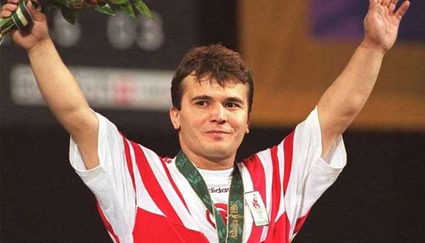 Naim Suleymanoglu of Turkey raising his arms at the medal ceremony in 1996