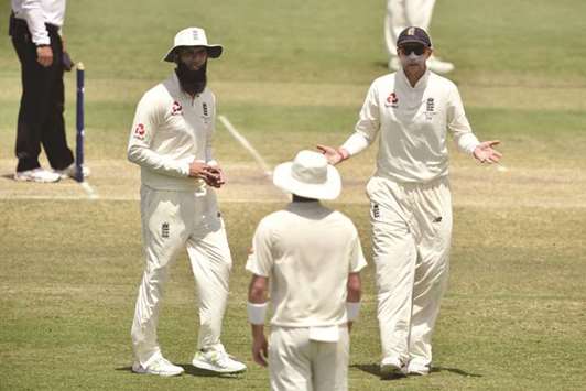 Englandu2019s captain Joe Root speaks to his two spinners Moeen Ali (left) and Mason Crane during the warm-up match against Australia XI at the Tony Ireland Stadium in Townsville, Queensland. (AFP)