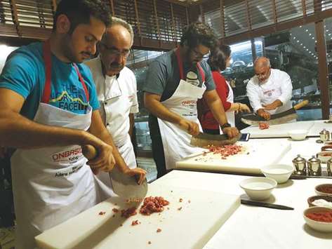 HANDS-ON: Social media influencers Hani al-Mousawi, right, and Jassim al-Ali, second from right, take part in a kebab-making and cooking workshop at Onba??lar Kebap restaurant in Adana. Photo by Joey Aguilar