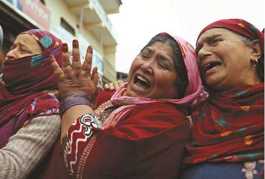 Women mourn as people carry the remains of Mugees Mir, a suspected militant who according to local media was killed in an encounter with the security forces in Zakura, during his funeral in Srinagar, yesterday.
