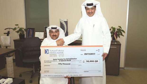 Ahmed al-Henzab hands over the donation to Taleb Abdullah Afifa.