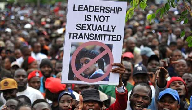 People hold an anti-Grace Mugabe placard during a demonstration demanding the resignation of Zimbabwe's president yesterday in Harare. AFP