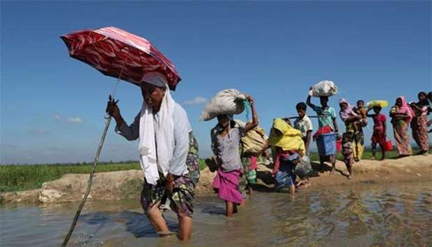 Rohingya walk towards a refugee camp after crossing the border in Anjuman Para near Cox's Bazar, Bangladesh on Sunday.