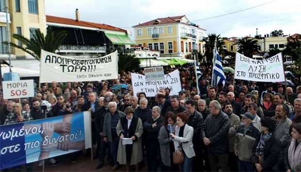 Residents of Lesbos island hold banners as they demonstrate in the town of Mytilene on Monday.