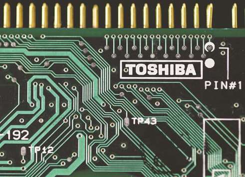 A logo of Toshiba is seen on a printed circuit board in Tokyo. Burdened by billions of dollars in liabilities at its bankrupt US nuclear reactor maker Westinghouse, Toshiba has been seeking to make up the difference by the end of the financial year in March or face a delisting.