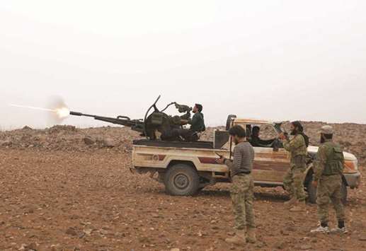 Syrian rebel fighters battle government forces near the village of Arafa, east of the city of Hama, yesterday.