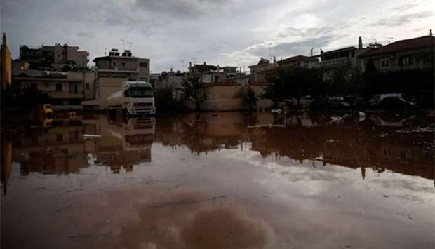 Houses are reflected in water, following flash floods which hit the town of Mandra, Greece.