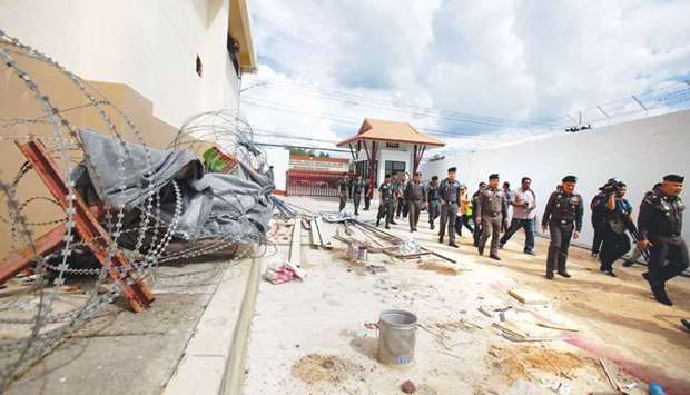 Police inspect the exterior of an immigration detention centre, from where 20 ethnic Uighurs escaped on Monday morning, in Sadao district in the southern Thai province of Songkhla yesterday.