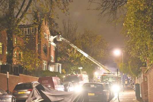 London Fire Brigade officials attend to the fire in north London yesterday.