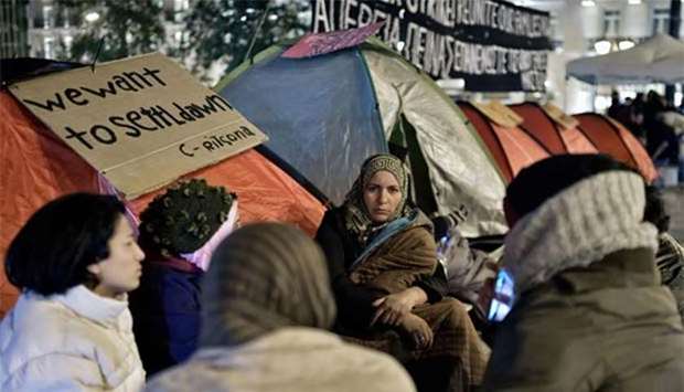 Refugees sit by their tents at the Athens central Syntagma square, as refugee families protest against delays in reuniting with their relatives in other European countries.