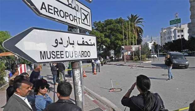 Tunisian bystanders check the scene of an attack on two traffic policemen in Tunis on Wednesday.