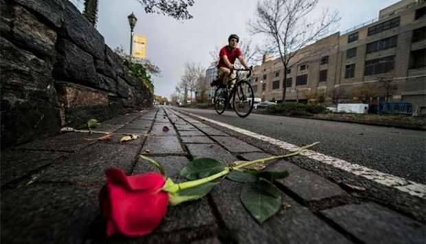 A cyclist rides past flowers left on a bike path for the New York terror attack victims, on Thursday.