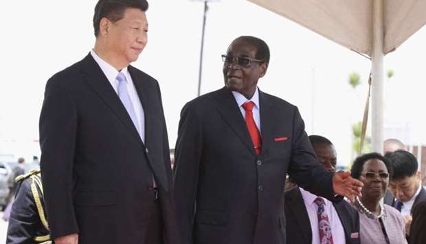 Chinese President Xi Jinping talks with Zimbabwean President Robert Mugabe on arrival for a state visit in Harare, Zimbabwe. File photo:  December 1, 2015