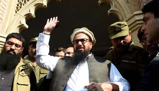Head of the Jamaat-ud-Dawa organisation Hafiz Saeed waves to supporters as he leaves a court in Lahore on Wednesday.