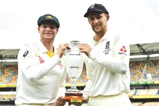 Australiau2019s skipper Steve Smith (left) and England captain Joe Root smile as they pose with the trophy in Brisbane yesterday. (AFP)