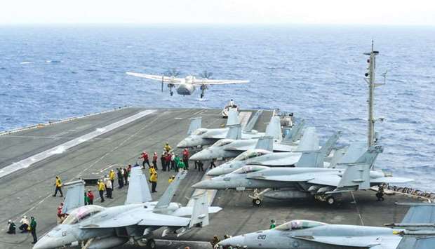 This handout picture released by the US Navy yesterday shows a C-2A Greyhound (top left) assigned to Fleet Logistics Support Squadron (VRC) 30 launching from the flight deck of the Navyu2019s forward-deployed aircraft carrier and flagship of Carrier Strike Group five, the aircraft carrier USS Ronald Reagan (CVN 76) in the Philippine Sea.