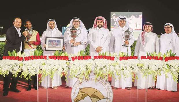 Qatar Racing and Equestrian Club general manager Nasser Sherida al-Kaabi (fourth from right) and vice-chief steward Abdulla Rashid al-Kubaisi (right) with the winners of Qatar Cup after Eduardo Pedroza guided Abdulatif Hussain al-Emadi-owned Mango Tango to victory in the 1700m feature yesterday. PICTURES: Juhaim