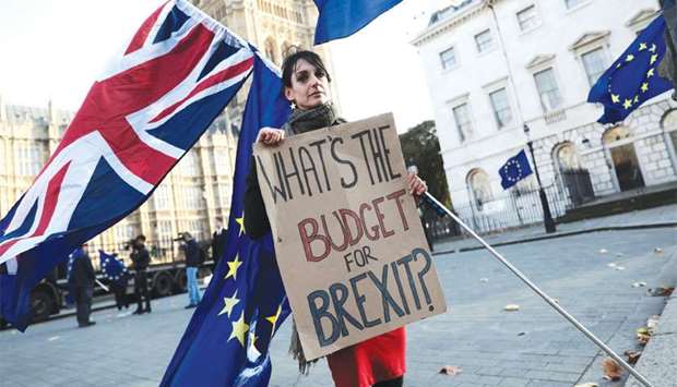 A protester holds a placard and British and EU flags outside Parliament in London yesterday.