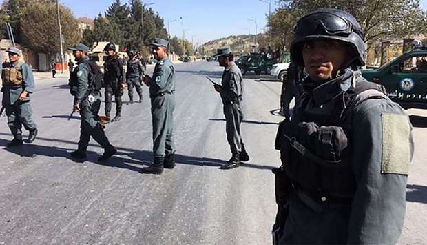 Afghan security forces stand guard near the site of a suicide attack