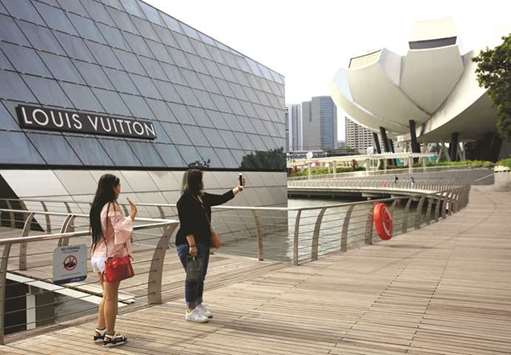 Shoppers take selfies in front of a Louis Vuitton shop in Singapore. The trade ministry said the Singapore economy expanded 5.2% on-year in July-September, accelerating from 2.9% in the previous three months and the fastest rate since the fourth quarter of 2013.