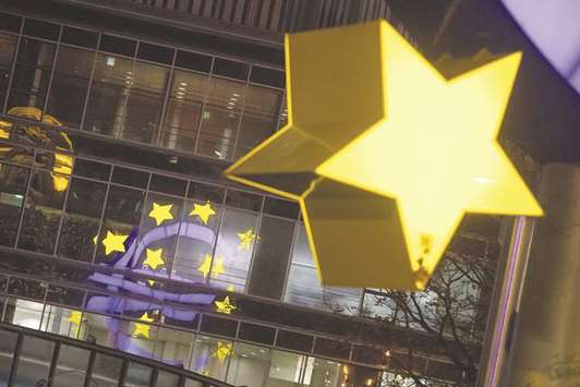 A star of the euro sign sculpture hangs illuminated near the former European Central Bank headquarters at night in Frankfurt. Minutes of the debate at the October 26 policy meeting suggest policymakers were far from unanimous, with some keen to signal a clear end to the ECBu2019s lavish asset purchases and others arguing for a change in emphasis as a precursor to their eventual end.