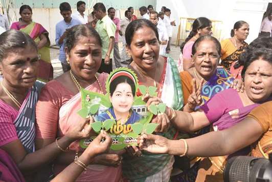 AIADMK workers of the ruling faction hold the newly allotted election symbol u201ctwo leavesu201d at the party headquarter in Chennai yesterday.
