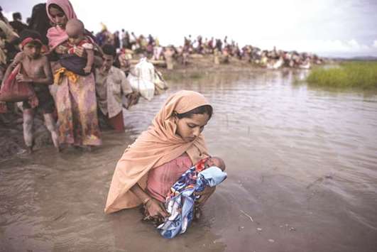 Rohingya refugees wading across the Naf river from Myanmar into Bangladesh in Whaikhyang.