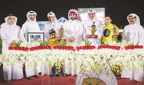 Qatar Racing and Equestrian Club (QREC) general manager Nasser Sherida al-Kaabi and deputy-chief steward Abdullah Rashid al-Kubaisi (right) with the winners of the Barzan Cup (Gr3) after Courtofversailles won the mile-long race at QREC yesterday. PICTURES: Juhaim